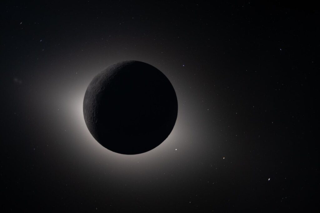Captured by the Artemis II crew during their lunar flyby on April 6, 2026, this image shows the Moon fully eclipsing the Sun. From the crew’s perspective, the Moon appears large enough to completely block the Sun, creating nearly 54 minutes of totality and extending the view far beyond what is possible from Earth. We see a glowing halo around the dark lunar disk. The science community is investigating whether this effect is due to the corona, zodiacal light, or a combination of the two. Also visible are stars, typically too faint to see when imaging the Moon, but with the Moon in darkness stars are readily imaged. This unique vantage point provides both a striking visual and a valuable opportunity for astronauts to document their observations during humanity’s return to deep space. The faint glow of the nearside of the Moon is visible in this image, having been illuminated by light reflected off the Earth. Editor's note: This caption was updated on April 8, 2026, to reflect ongoing scientific observations and discussion about the image.