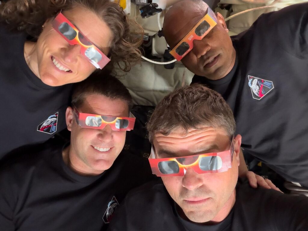 The Artemis II crew – Mission Specialist Christina Koch (top left), Mission Specialist Jeremy Hansen (bottom left), Commander Reid Wiseman (bottom right), and Pilot Victor Glover (top right) – uses eclipse viewers, identical to what NASA produced for the 2023 annular eclipse and 2024 total solar eclipse, to protect their eyes at key moments during the solar eclipse they experienced during their lunar flyby. This was the first use of eclipse glasses at the Moon to safely view a solar eclipse.